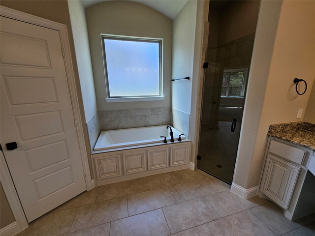 bathroom featuring vanity, shower with separate bathtub, lofted ceiling, and tile patterned flooring