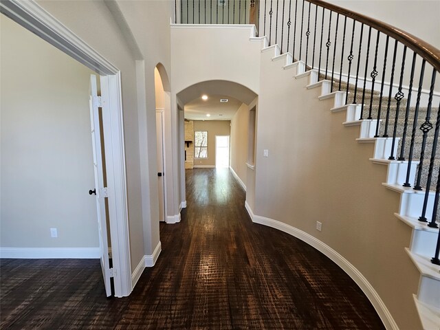 hall featuring a high ceiling and dark hardwood / wood-style flooring