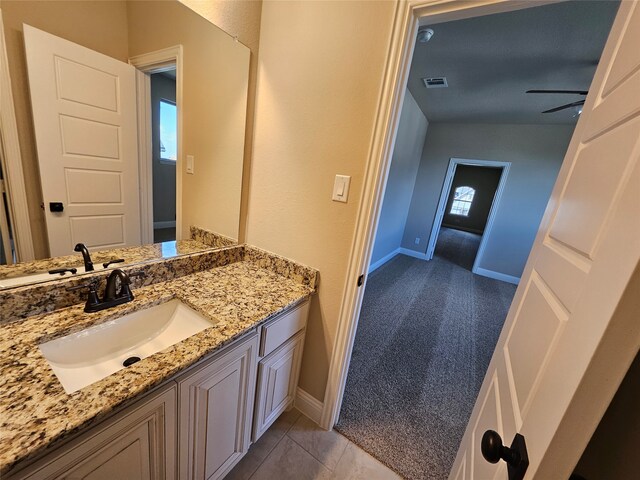 bathroom featuring lofted ceiling, vanity, ceiling fan, and tile patterned flooring