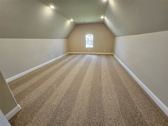 additional living space with carpet flooring and vaulted ceiling