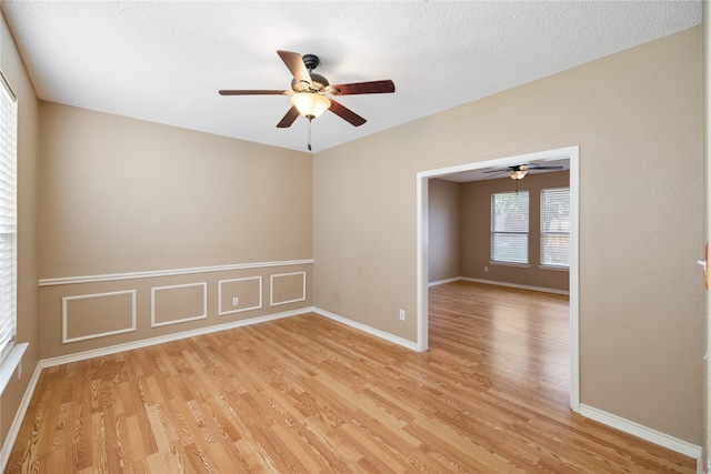 unfurnished room featuring a textured ceiling, light hardwood / wood-style flooring, and ceiling fan