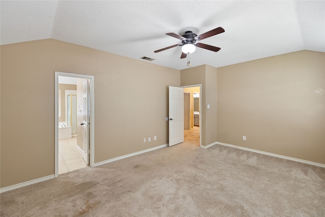 spare room featuring a textured ceiling, ceiling fan, lofted ceiling, and light tile patterned floors