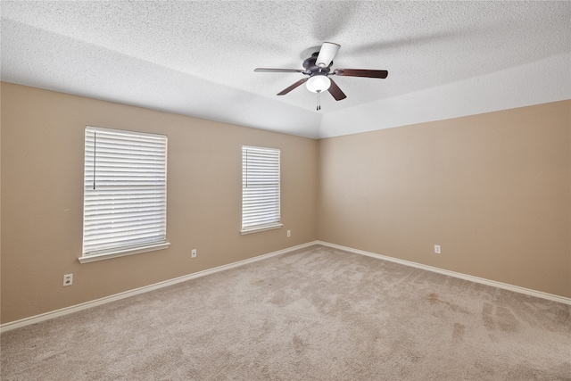 empty room with light carpet, a textured ceiling, and ceiling fan