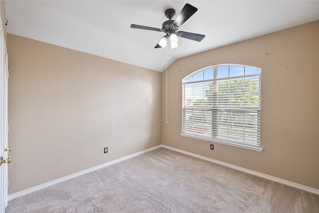 carpeted spare room featuring lofted ceiling and ceiling fan