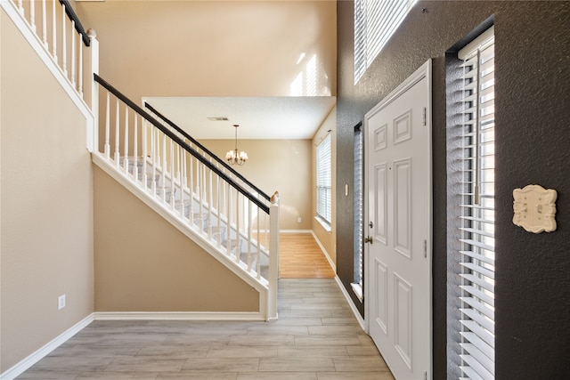 foyer with light hardwood / wood-style floors and a chandelier