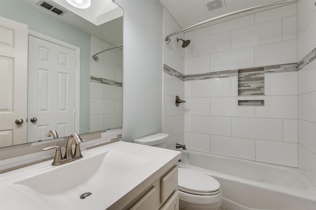 full bathroom with vanity, tiled shower / bath combo, and toilet