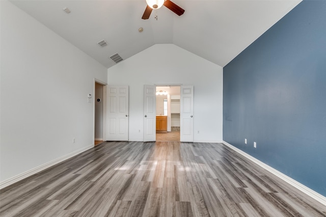 interior space with ceiling fan, wood-type flooring, and lofted ceiling