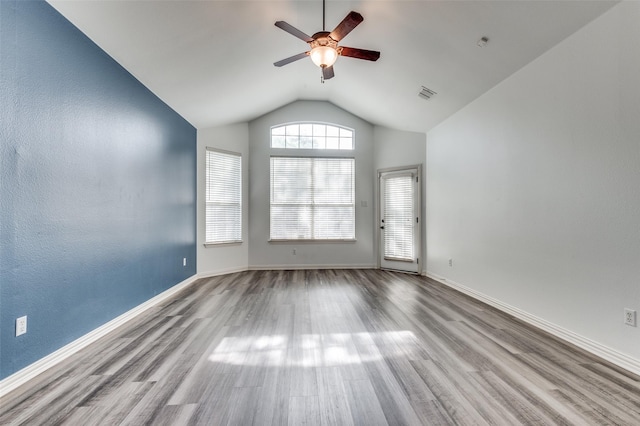 empty room with lofted ceiling, ceiling fan, and light hardwood / wood-style flooring