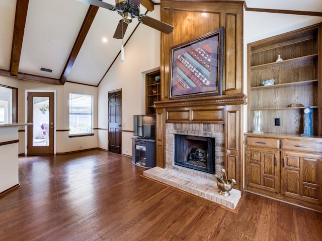 unfurnished living room featuring beamed ceiling, a fireplace, dark hardwood / wood-style floors, and ceiling fan