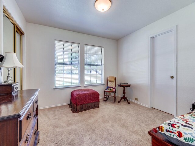 bedroom featuring light carpet and a closet