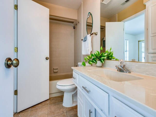 full bathroom with washtub / shower combination, tile patterned floors, toilet, and vanity