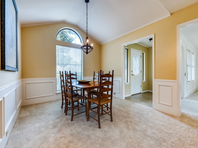 dining area with an inviting chandelier, crown molding, lofted ceiling, and light colored carpet