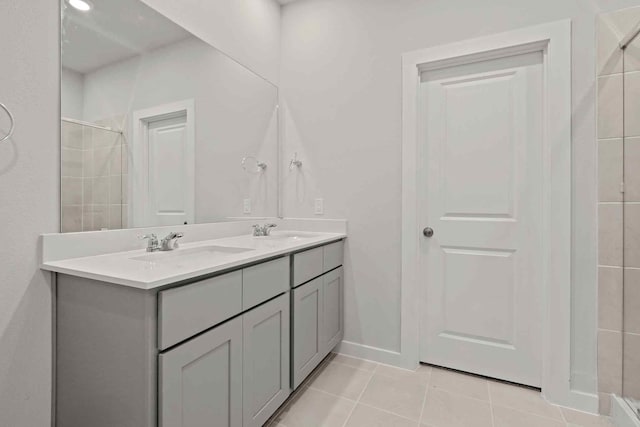 bathroom with tile patterned flooring, vanity, and a shower