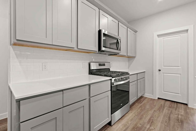 kitchen featuring gray cabinetry, light hardwood / wood-style flooring, and stainless steel appliances