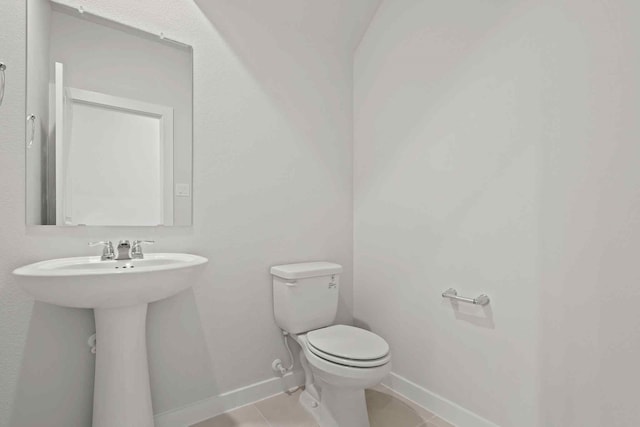 bathroom featuring tile patterned floors, toilet, and sink