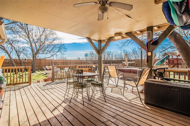 wooden terrace with a playground and ceiling fan