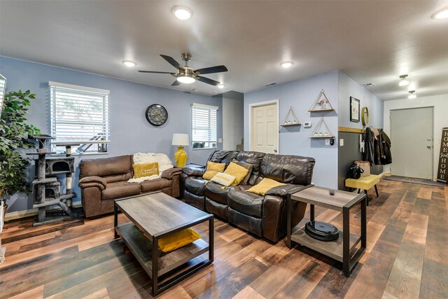 living room with a healthy amount of sunlight, dark hardwood / wood-style flooring, and ceiling fan