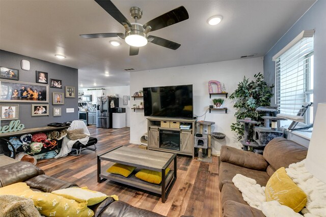 living room featuring dark hardwood / wood-style flooring and ceiling fan