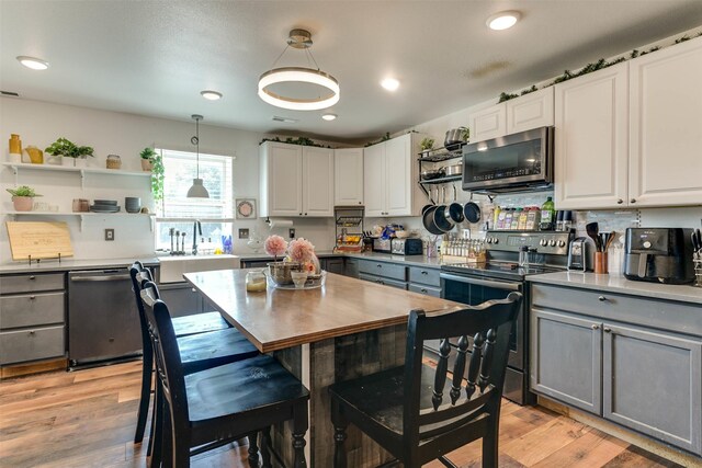 kitchen featuring white cabinetry, appliances with stainless steel finishes, light wood-type flooring, and gray cabinetry