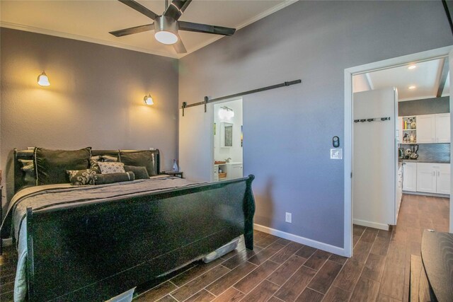 bedroom featuring dark wood-type flooring, ensuite bathroom, a barn door, and ceiling fan