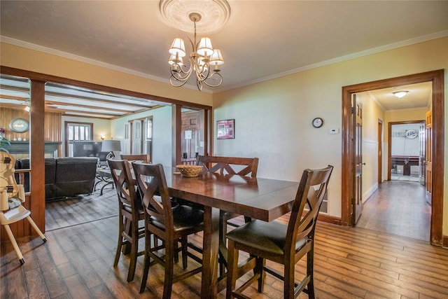 dining area with beamed ceiling, ornamental molding, hardwood / wood-style floors, and an inviting chandelier