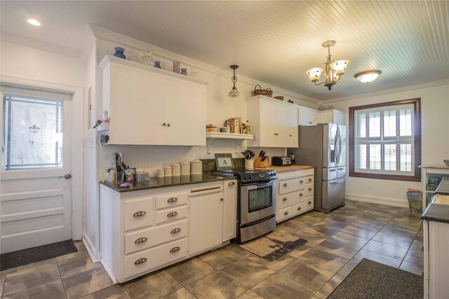 kitchen with a chandelier, pendant lighting, appliances with stainless steel finishes, and dark tile patterned flooring