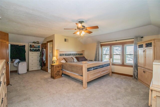 carpeted bedroom featuring ceiling fan, vaulted ceiling, and a closet