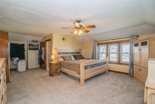 bedroom featuring lofted ceiling, baseboards, visible vents, and light colored carpet