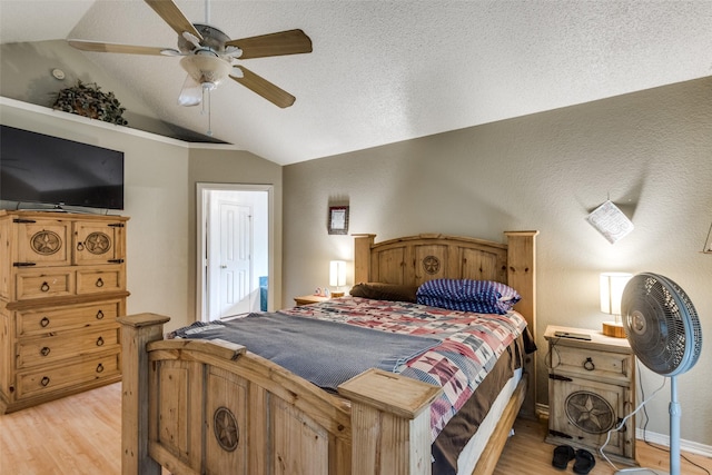 bedroom featuring lofted ceiling, hardwood / wood-style floors, and a textured ceiling