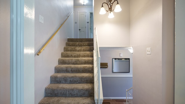 staircase featuring an inviting chandelier