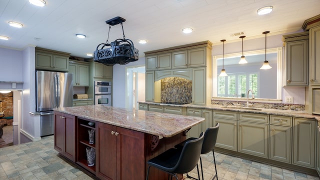 kitchen with sink, decorative light fixtures, a center island, and appliances with stainless steel finishes