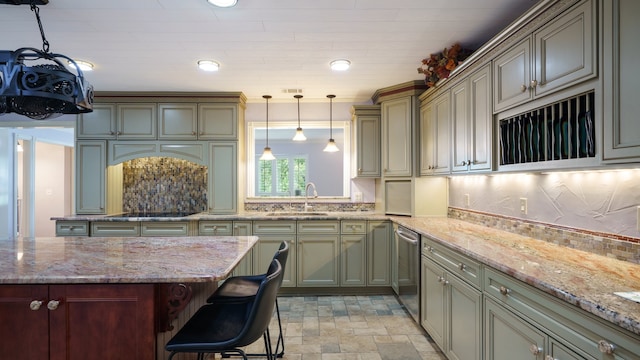 kitchen with light tile patterned flooring, backsplash, sink, light stone counters, and a kitchen breakfast bar