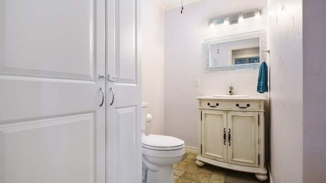 bathroom featuring vanity, crown molding, tile patterned flooring, and toilet