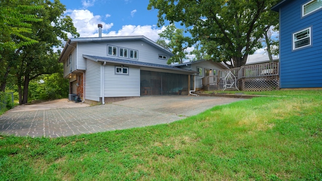 rear view of property with cooling unit and a yard