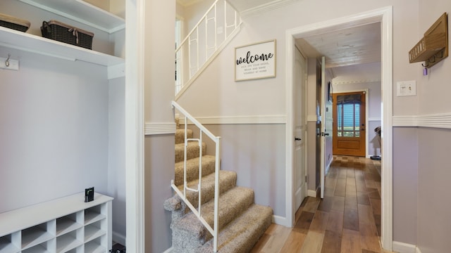 stairway featuring hardwood / wood-style flooring and crown molding