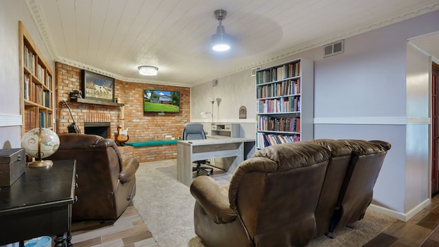 living room with brick wall, ornamental molding, a brick fireplace, and light hardwood / wood-style floors