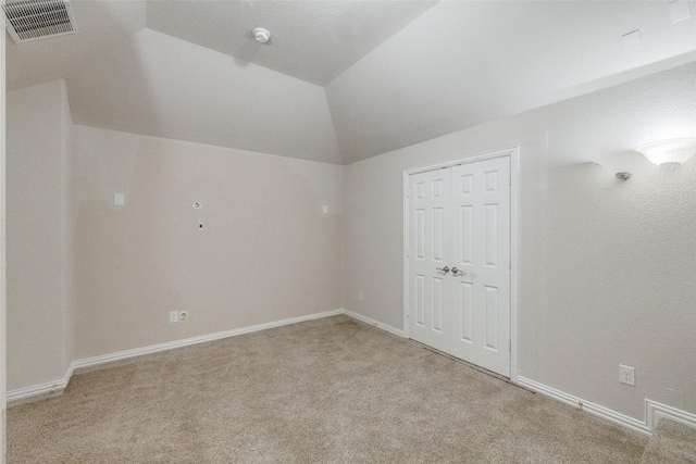 additional living space with carpet floors, baseboards, visible vents, and vaulted ceiling