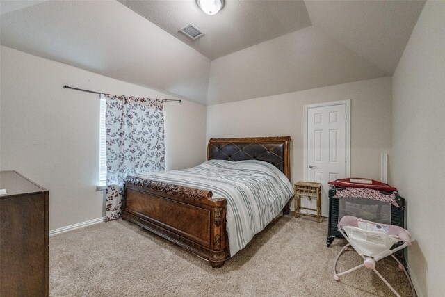 carpeted bedroom with lofted ceiling, baseboards, and visible vents