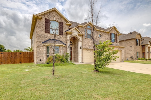 traditional home with brick siding, concrete driveway, an attached garage, a front yard, and fence