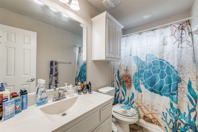 bathroom featuring a shower with shower curtain, a textured wall, vanity, and toilet