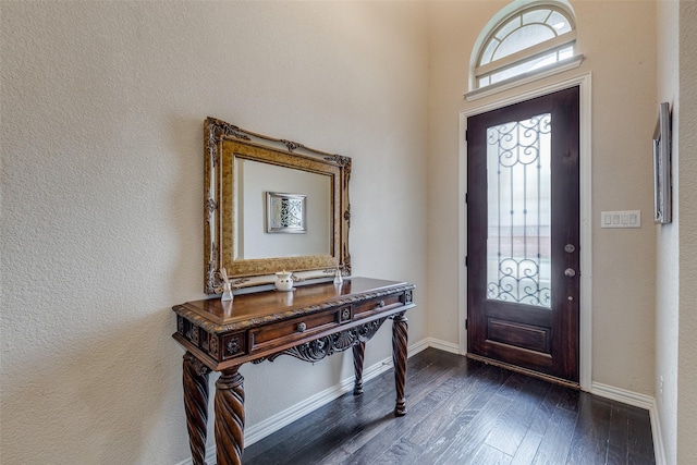 foyer featuring dark wood-style floors and baseboards