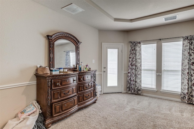 bedroom featuring access to exterior, visible vents, a raised ceiling, and carpet flooring