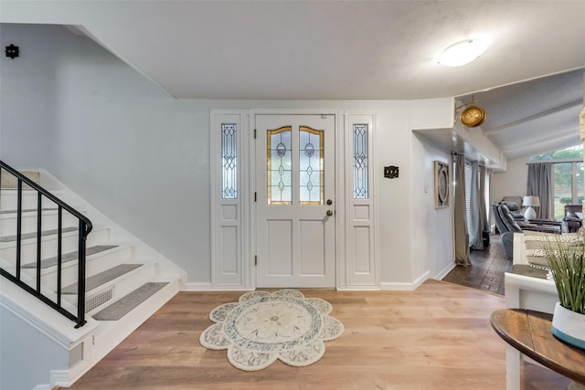 entryway with vaulted ceiling and wood-type flooring