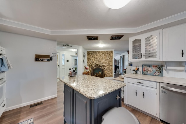 kitchen featuring white cabinetry, dishwasher, a kitchen island, and light hardwood / wood-style floors