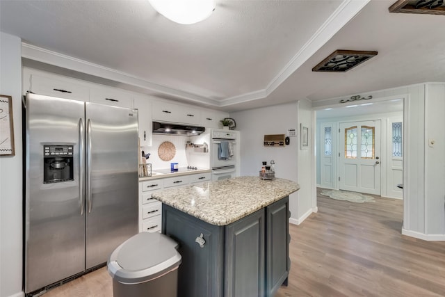 kitchen featuring white cabinets, stainless steel fridge, light stone countertops, black electric cooktop, and light hardwood / wood-style flooring