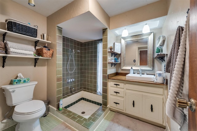 bathroom featuring tile patterned flooring, vanity, tiled shower, and toilet