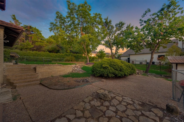 yard at dusk with a patio area