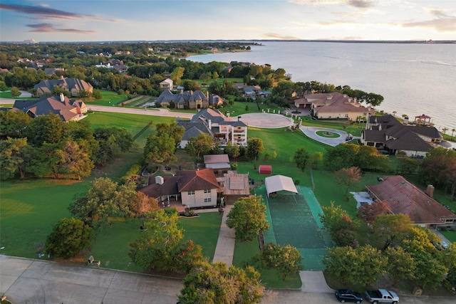 aerial view at dusk featuring a water view