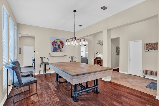 dining room with hardwood / wood-style flooring and an inviting chandelier