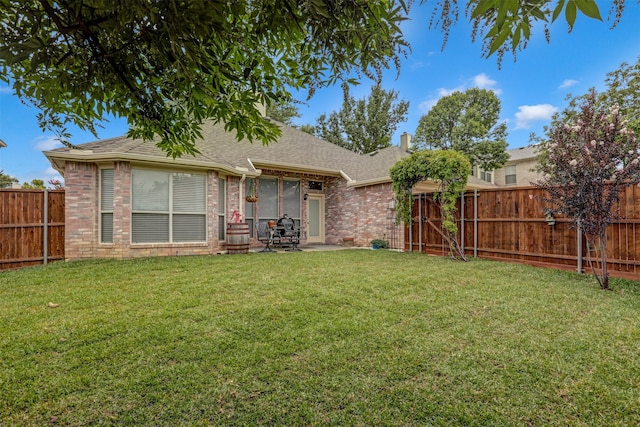 rear view of house with a patio and a yard